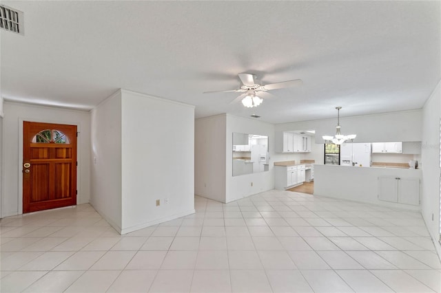 unfurnished living room with a textured ceiling, light tile patterned flooring, and ceiling fan with notable chandelier