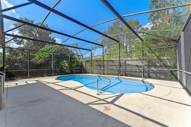 view of swimming pool featuring a patio area and glass enclosure