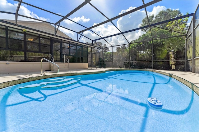 view of swimming pool featuring a patio and a lanai