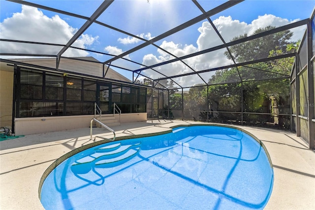 view of swimming pool featuring a patio area and a lanai