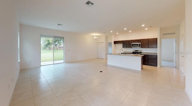 kitchen featuring a center island with sink, sink, appliances with stainless steel finishes, and light tile patterned floors