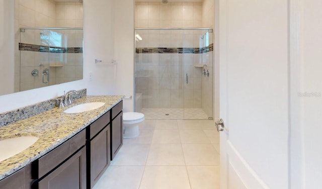 bathroom with toilet, a shower with shower door, vanity, and tile patterned floors