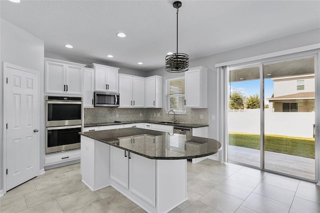 kitchen featuring a wealth of natural light, a center island, stainless steel appliances, and white cabinetry