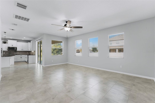 tiled empty room featuring sink, a textured ceiling, and ceiling fan