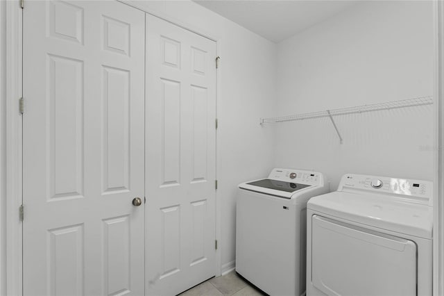 clothes washing area with separate washer and dryer and light tile patterned floors