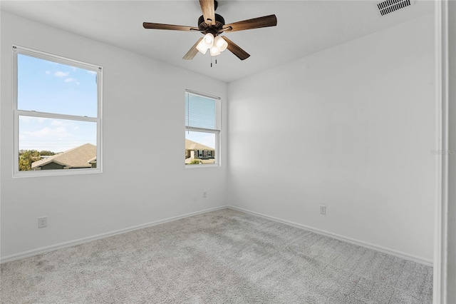 carpeted spare room featuring ceiling fan