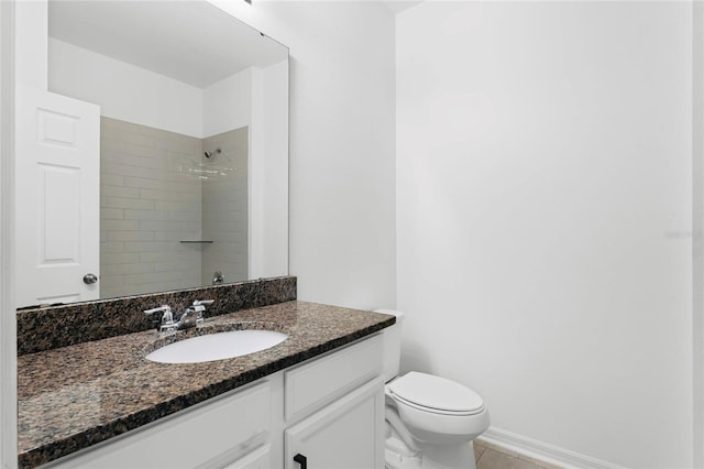 bathroom with vanity, toilet, tile patterned floors, and tiled shower