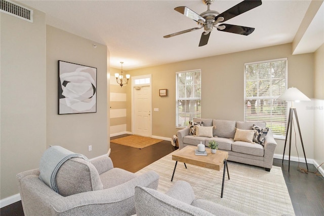 living room featuring ceiling fan with notable chandelier, plenty of natural light, and dark hardwood / wood-style flooring