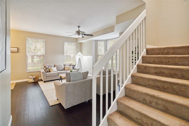 living room featuring ceiling fan, a textured ceiling, and hardwood / wood-style floors