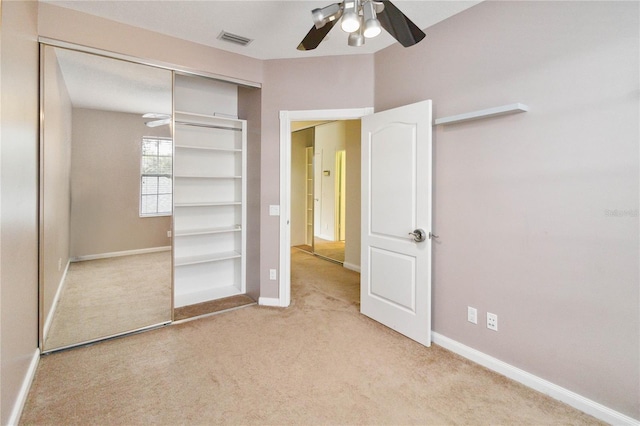 unfurnished bedroom featuring a closet, ceiling fan, and light carpet