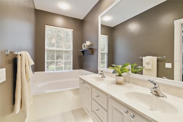 bathroom featuring a bath, tile patterned floors, a textured ceiling, and vanity