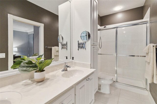 bathroom featuring toilet, tile patterned flooring, vanity, a textured ceiling, and walk in shower