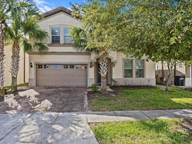 8832 Macapa Dr, Kissimmee, FL 34747 - view of front of house featuring decorative driveway, stucco siding, an attached garage, and a front lawn