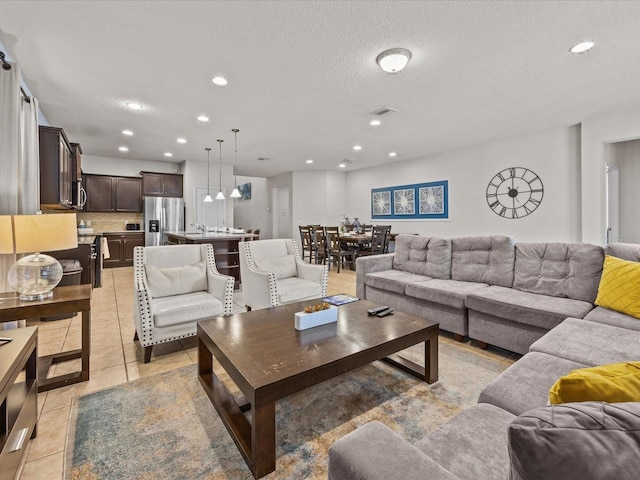 living room with a textured ceiling and light tile patterned floors