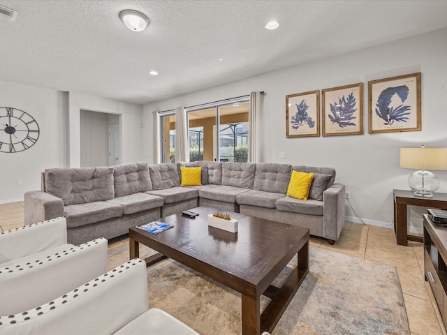 living room featuring a textured ceiling and light tile patterned floors