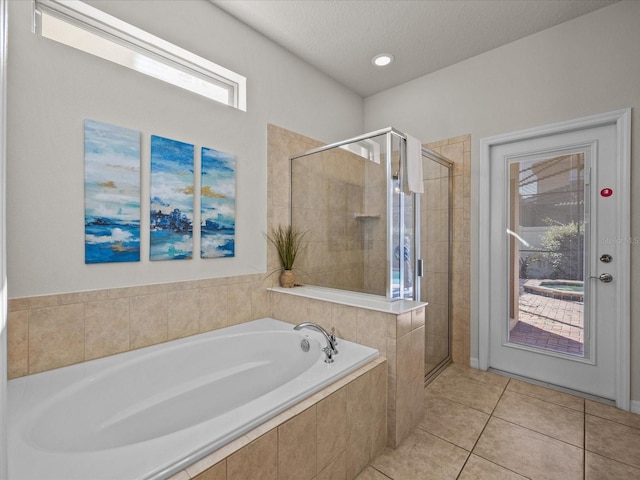 bathroom with a textured ceiling, tile patterned flooring, and plus walk in shower