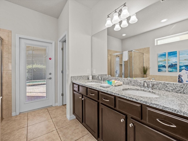 bathroom with vanity, tile patterned flooring, a healthy amount of sunlight, and walk in shower