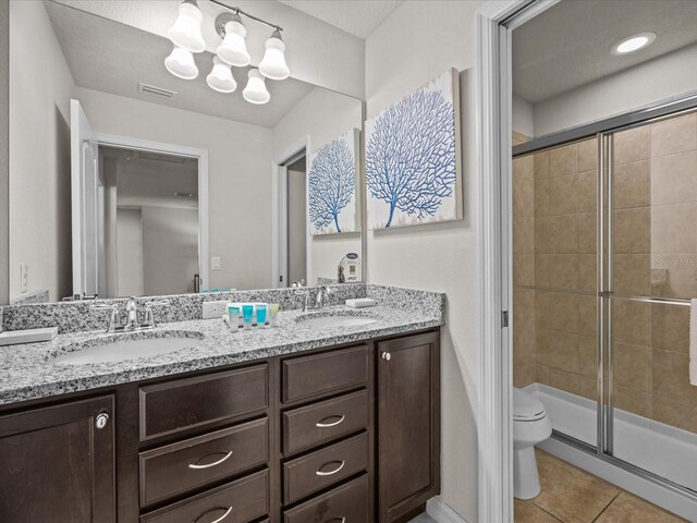 8832 Macapa Dr, Kissimmee, FL 34747 - bathroom with toilet, tile patterned floors, a stall shower, double vanity, and a chandelier