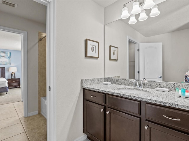 bathroom featuring vanity, tiled shower / bath combo, and tile patterned floors