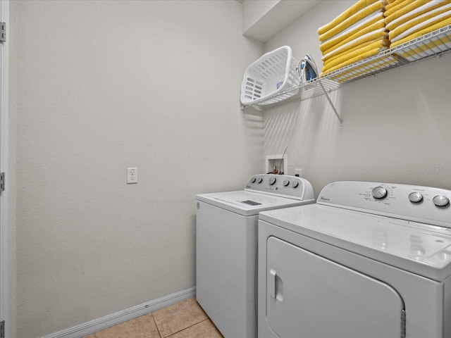 washroom featuring washing machine and clothes dryer and light tile patterned floors