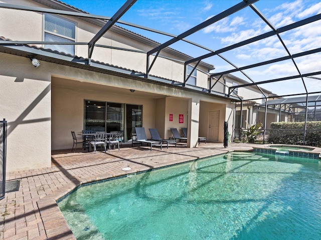 view of pool featuring a patio, an in ground hot tub, and glass enclosure