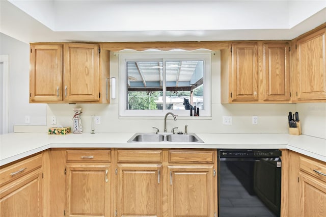 kitchen with light countertops, black dishwasher, and a sink