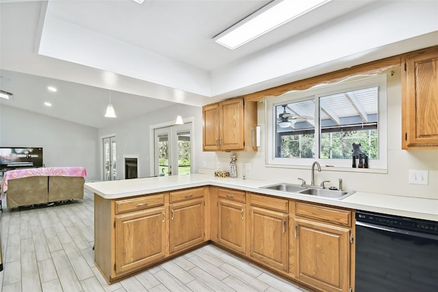 kitchen featuring a peninsula, black dishwasher, a wealth of natural light, and a sink