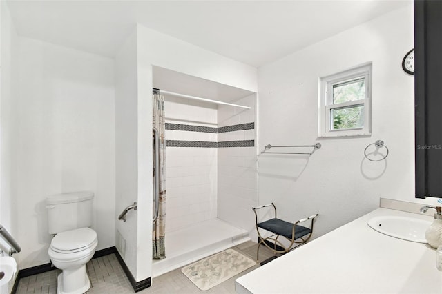 bathroom featuring toilet, baseboards, a stall shower, and a sink