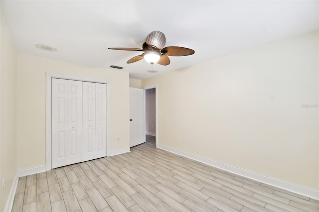 unfurnished bedroom featuring light wood-type flooring, visible vents, a closet, baseboards, and ceiling fan