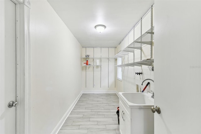 interior space featuring a sink, baseboards, and laundry area