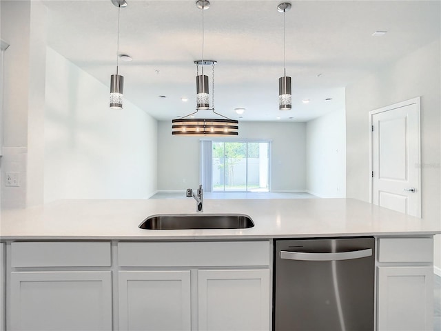 kitchen featuring white cabinetry, sink, stainless steel dishwasher, and decorative light fixtures