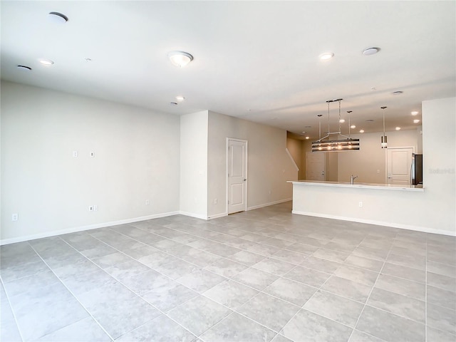 unfurnished living room featuring sink and light tile patterned floors