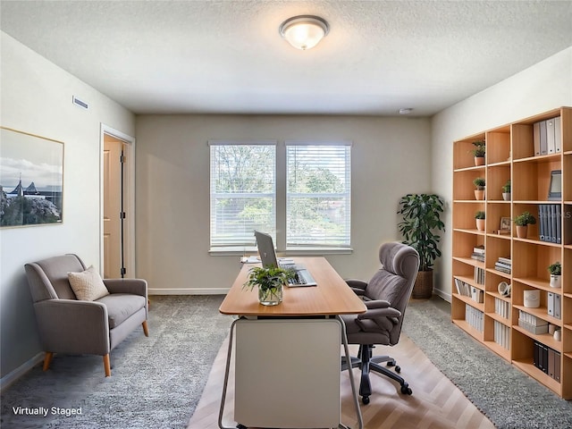 office area with light hardwood / wood-style flooring and a textured ceiling