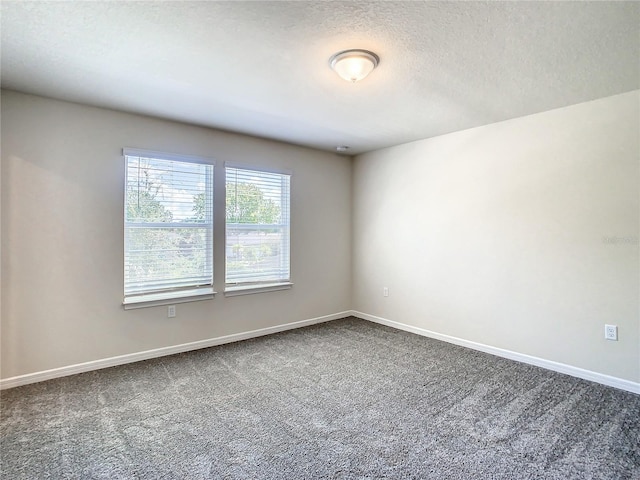 carpeted spare room with a textured ceiling