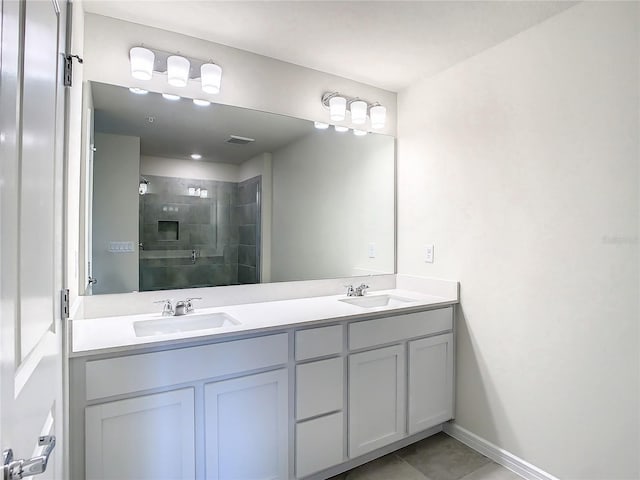 bathroom with a shower with door, tile patterned flooring, and vanity