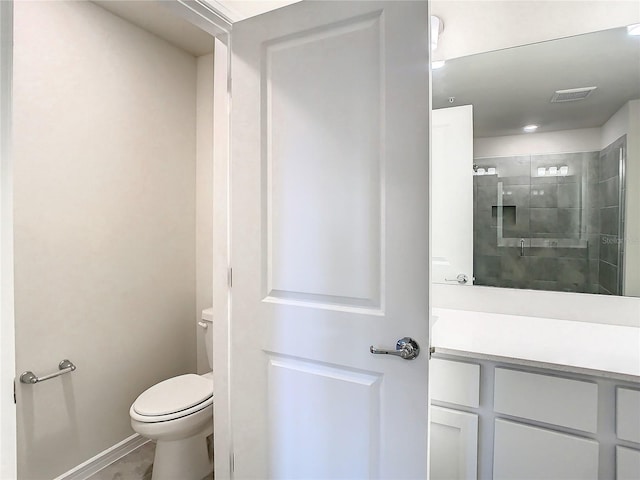 bathroom featuring vanity, toilet, and an enclosed shower