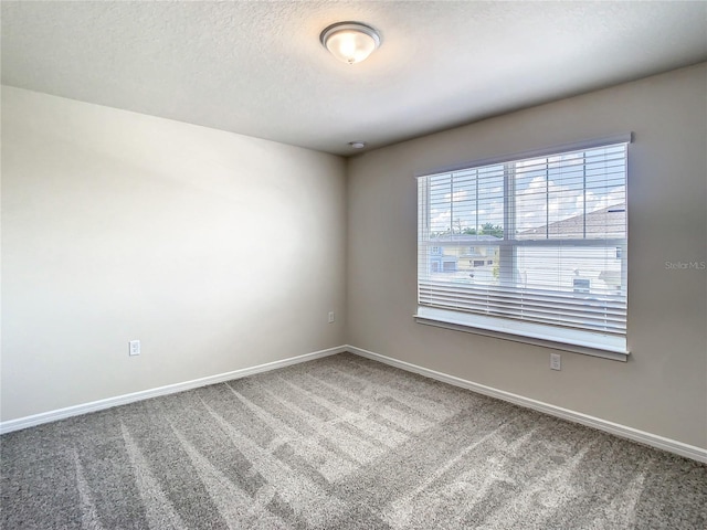 carpeted spare room with a textured ceiling