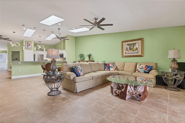 tiled living room featuring ceiling fan and lofted ceiling with skylight