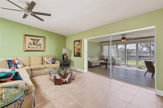 living room with ceiling fan, light tile patterned floors, and vaulted ceiling