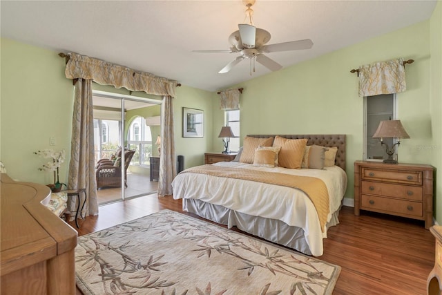 bedroom with ceiling fan, access to exterior, wood-type flooring, and multiple windows