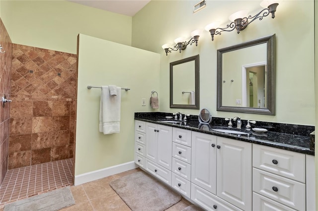 bathroom featuring vanity, tile patterned floors, and tiled shower