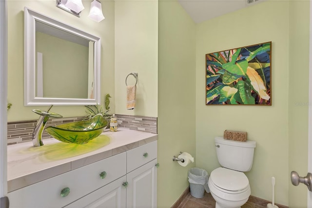 bathroom with toilet, vanity, decorative backsplash, and tile patterned floors