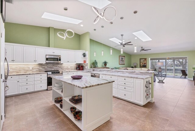 kitchen with pendant lighting, white cabinets, stainless steel appliances, and a kitchen island