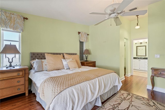 bedroom featuring ceiling fan, connected bathroom, and dark hardwood / wood-style flooring