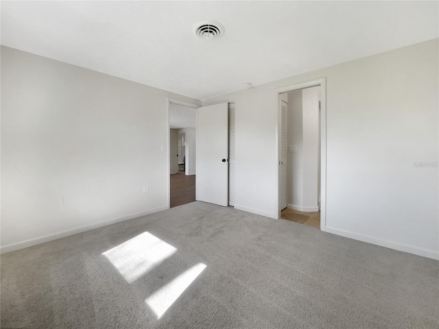 unfurnished bedroom featuring light colored carpet and a closet