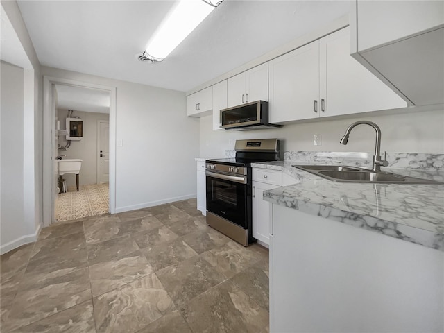 kitchen with sink, light stone countertops, white cabinetry, electric panel, and appliances with stainless steel finishes