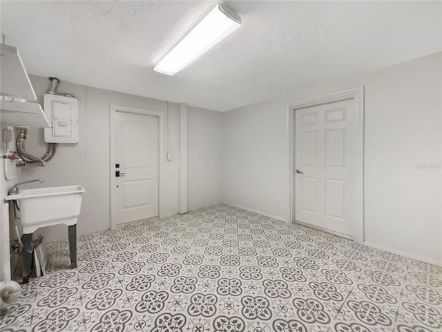 basement with a textured ceiling and electric panel