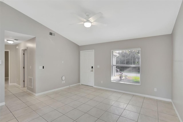 tiled empty room featuring vaulted ceiling and ceiling fan