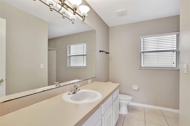 bathroom with toilet, vanity, and tile patterned floors