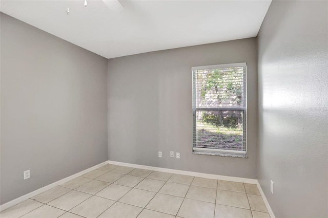 tiled spare room featuring ceiling fan